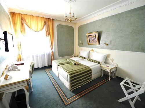 贝尔格莱德皇后阿斯托利亚设计酒店的配有一张床和一张书桌的酒店客房