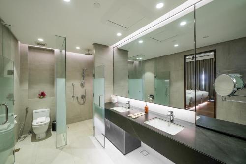 萨马尔Discovery Samal的浴室设有2个水槽、卫生间和镜子。