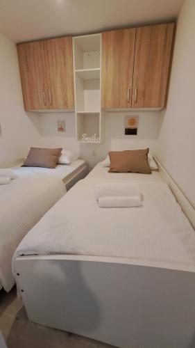 德拉格Premium mobile home Maslina - Oaza mira的配有木柜的客房内的两张床