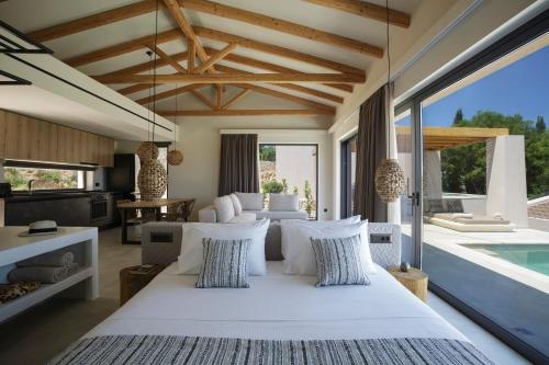 Andipáta ErísouAmahle Luxury Villas 2023的一间带大床的卧室和一个游泳池