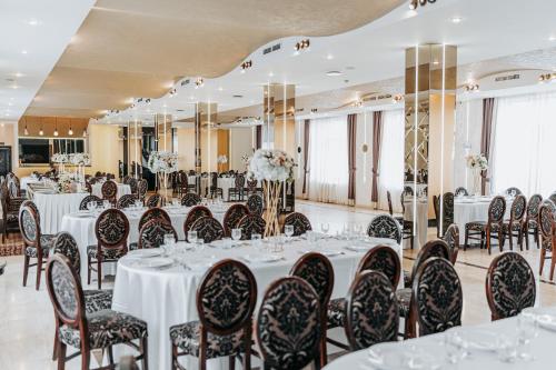 锡比乌Hotel Bliss的宴会厅配有白色的桌椅