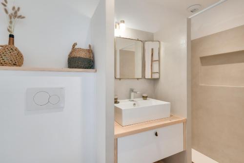 里夫杜海滩Cocon apaisant a Rivedoux Plage的浴室设有白色水槽和镜子