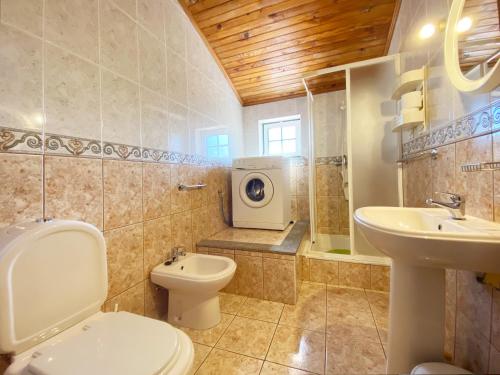安旱斯达塞拉Casa da Risca的浴室配有卫生间水槽和洗衣机。