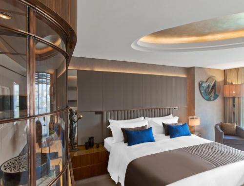 伊斯坦布尔伊斯坦布尔瑞吉酒店的一间卧室配有一张带蓝色枕头的大床