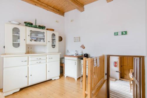 OdryVodní mlýn Wesselsky的厨房铺有木地板,配有白色橱柜。
