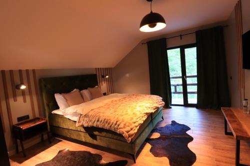 RausorWild Hunts Lodge Retezat的一间卧室设有一张大床,铺有木地板