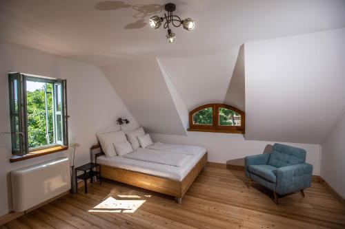 KékkútOszter Udvarház的一间卧室配有一张床和一张蓝色椅子