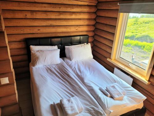 阿克雷里Akureyri Loghouse的小木屋内的一张床位,设有窗户