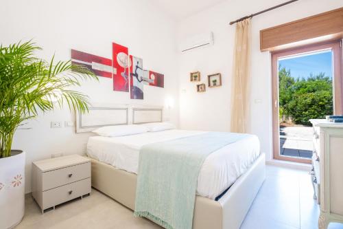 丽都玛里尼Villa Crigiada Luxury Pool的白色的卧室设有床和窗户