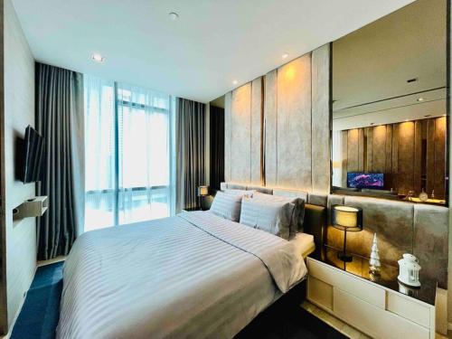 曼谷Luxurious in Prime Area Bangkok (PickupService)的一间卧室设有一张大床和一个大窗户