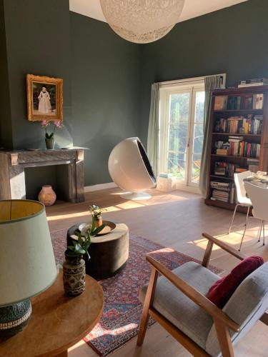 奥弗芬Suites Elswoutshoek的客厅设有绿色的墙壁和桌椅