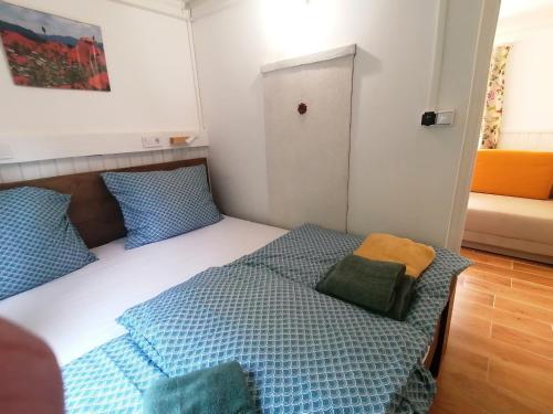 KismarosBarkóca és Szépkilátás Vendégház / Cabin的一间卧室配有一张带蓝色和绿色枕头的床