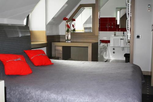 诺维萨德利奥波德一世加尼酒店的一间卧室配有一张带红色枕头的大床