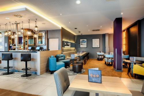 莱比锡Premier Inn Leipzig City Hahnekamm的一间带桌椅的餐厅和一间酒吧