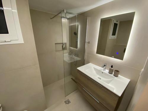 托隆Hotel Pavlos - Studios的白色的浴室设有水槽和淋浴。