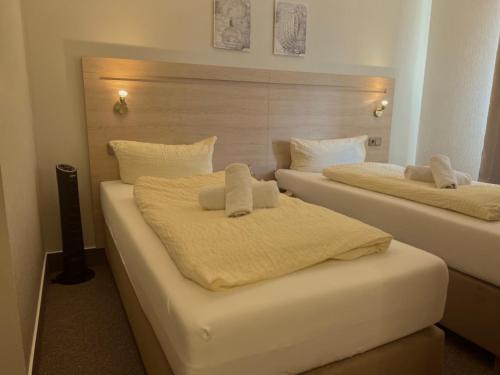 阿沙芬堡桑德豪斯阿尔特斯酒店的客房内的两张床和毛巾