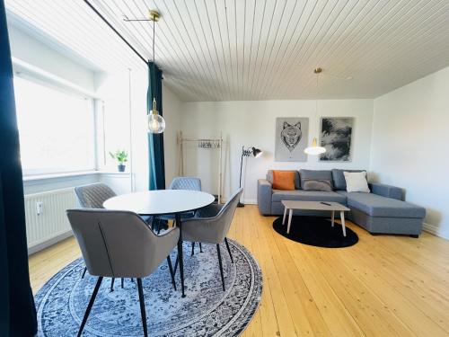 Nørresundbyaday - Modern charming apartment in Noerresundby的客厅配有沙发和桌椅