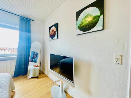 Nørresundbyaday - Modern charming apartment in Noerresundby的卧室配有壁挂式平面电视