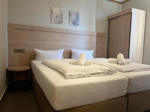 阿沙芬堡桑德豪斯阿尔特斯酒店的一间卧室配有两张带白色床单的床