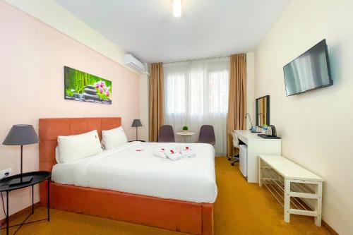塞萨洛尼基City Plaza Apartments & Rooms的酒店客房配有一张床、一张书桌和一台电视。