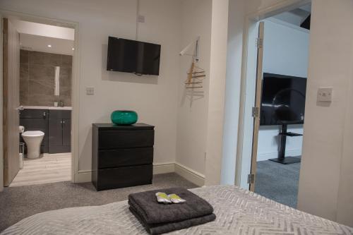 赫尔#5 Grimston St Apartment near Hull New Theatre and Connexin Live的一间卧室配有一张床、一台电视和一间浴室。