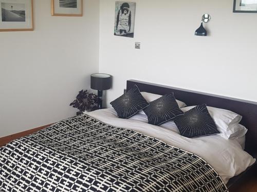 拉恩Powis Cottage的一张配有黑白床单和枕头的床