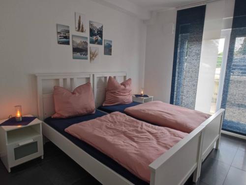 莫尔斯Moers City Apartments的卧室内的两张床,配有粉红色的床单和枕头