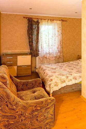 文茨皮尔斯Anniņas的卧室配有床、椅子和窗户。