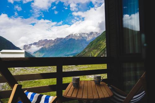 卡兹贝吉Patara cottage, Stepantsminda, Achkhoti,的阳台享有桌子和山脉的美景。