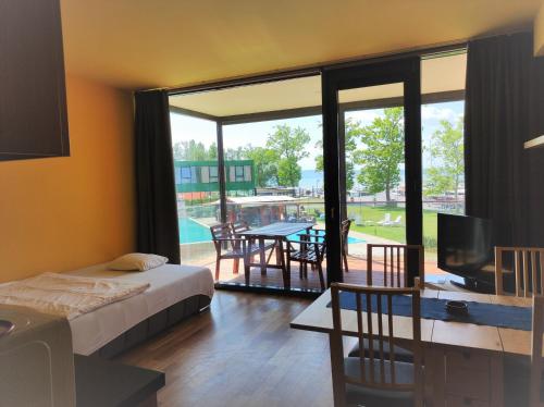 巴拉通雷勒Soleil Apartmanok Balatonlelle的一间卧室配有一张床、一台电视和一个庭院。