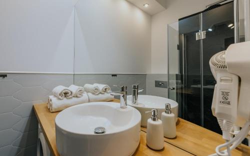 弗罗茨瓦夫Stare Kasyno Aparthotel的白色的浴室设有水槽和淋浴。