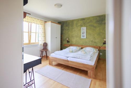 洛伊查赫Bauernhof Kure的一间卧室配有一张床和一张书桌