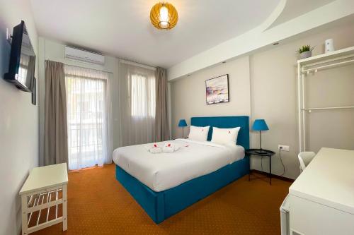 塞萨洛尼基City Plaza Apartments & Rooms的一间卧室配有一张大床和蓝色床头板