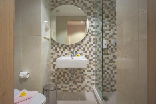 泗水Regantris Surabaya的一间带水槽、卫生间和镜子的浴室