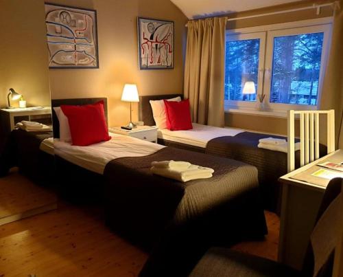 萨翁林纳Norppa Resort的酒店客房设有两张床和窗户。