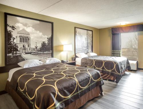 印第安纳波利斯速8南印第安纳波利斯酒店的酒店客房带两张床,还有一幅建筑图