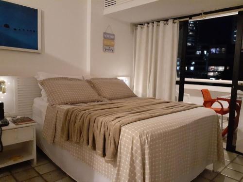 萨尔瓦多Studio encantador com vista mar的一间卧室配有一张带窗户和桌子的床