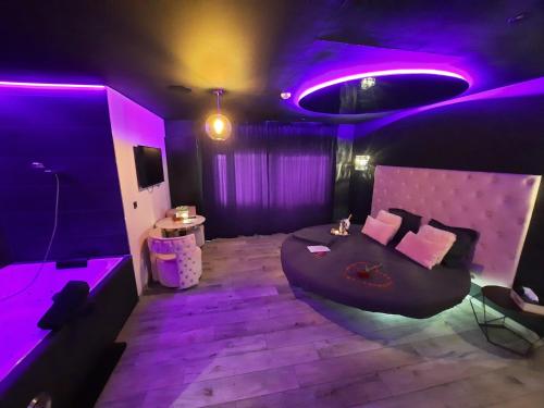 列日Nuits Blanches的紫色的客房配有一张床和一张桌子