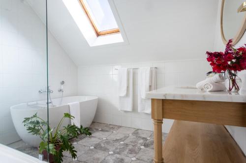 斯泰伦博斯Rozendal Stay的浴室配有白色浴缸、盥洗盆和浴缸。