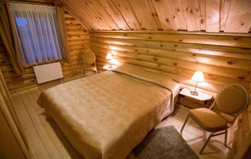 帕兰加Meguva Resort Hotel的小木屋内的卧室,配有一张床和两把椅子