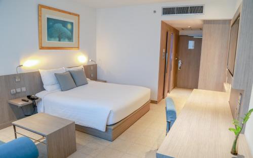 曼那曼谷班纳诺富特酒店的酒店客房配有一张床铺和一张桌子。