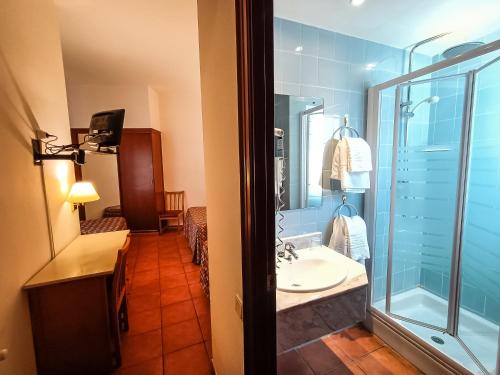 坎布里尔斯Hotel Can Solé的一间带水槽和玻璃淋浴的浴室