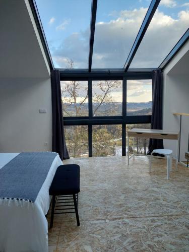 ValhelhasQuinta da Pedrulha的一间卧室设有一张床和一个大型玻璃窗