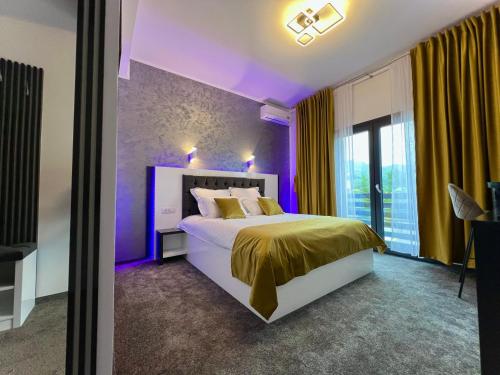 大盐矿镇Bigala Ocnele Mari的紫色卧室设有一张床和一个窗户