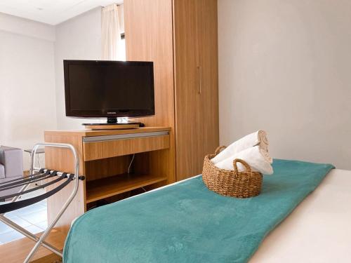 戈亚尼亚STAY Sun Square的客房设有一张带电视和椅子的床。