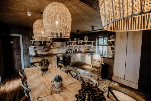 巴纳德城堡Runa Farm的厨房配有木桌、椅子和吊灯。