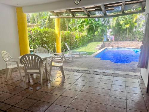 圣何塞港Casa Villas del Pacifico Puerto San José的一个带桌椅的庭院和一个游泳池