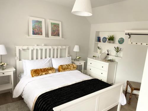 BlackfordbyThe Wren的白色卧室配有带金色枕头的白色床