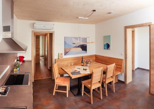 毛特恩艾德维尼斯加特豪斯尼科来霍夫加尔尼酒店的厨房以及带木桌和椅子的用餐室。