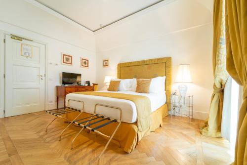 马丁纳弗兰卡Relais Villa San Martino的一间卧室配有一张大床和电视